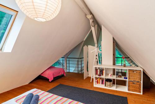 a small attic room with a staircase and a book shelf at Gutshof Kaiserbacher Mühle in Klingenmünster
