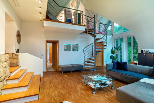 a living room with a staircase and a couch at Gutshof Kaiserbacher Mühle in Klingenmünster