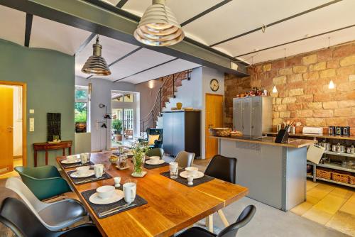 a kitchen and dining room with a wooden table and chairs at Gutshof Kaiserbacher Mühle in Klingenmünster