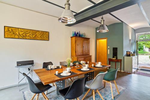 a dining room with a wooden table and chairs at Gutshof Kaiserbacher Mühle in Klingenmünster
