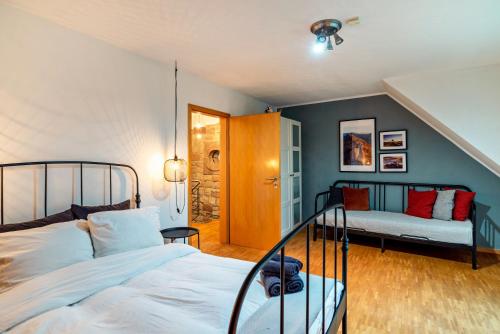a bedroom with a bed and a couch at Gutshof Kaiserbacher Mühle in Klingenmünster