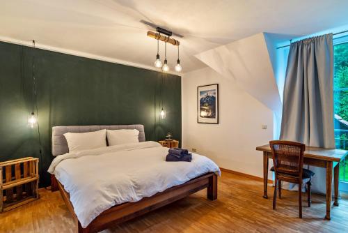 a bedroom with a green wall and a desk and a bed at Gutshof Kaiserbacher Mühle in Klingenmünster