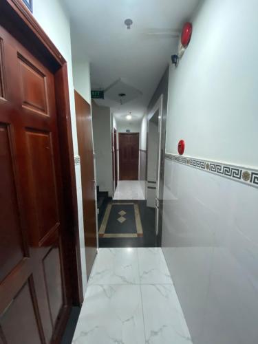 - un couloir dans un bâtiment avec une porte et du carrelage dans l'établissement Khách sạn Thanh Bình 3, à Hô-Chi-Minh-Ville