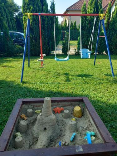 un bac à sable avec un château de sable dans un parc dans l'établissement Petra Apartmanház, à Kehidakustány