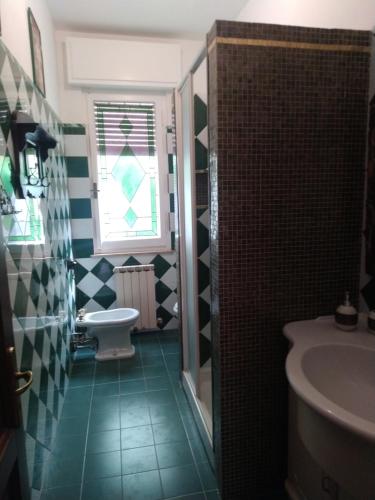 a bathroom with a sink and a toilet and a window at la casa di Aldo in Perugia