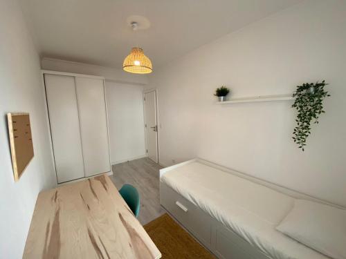 Carcavelos beach walking distance room in shared apartment في أويراس: غرفة صغيرة بها سرير وضوء