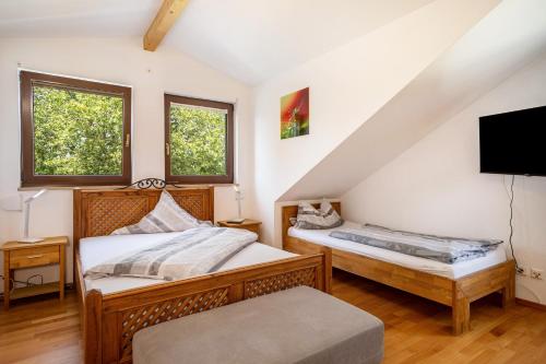 1 dormitorio con 2 camas y TV en Ferienwohnung Zur Imme en Lindau