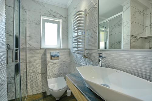 uma casa de banho com uma banheira, um WC e um lavatório. em olszanka em Ustrzyki Dolne