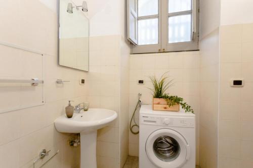 y baño con lavadora y lavamanos. en Sicily Loft Catania few min from sea - Happy Rentals, en Catania