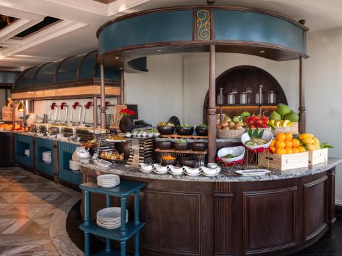 a kitchen with a counter with fruits and vegetables at GRAND HOTEL du LAC Hanoi in Hanoi