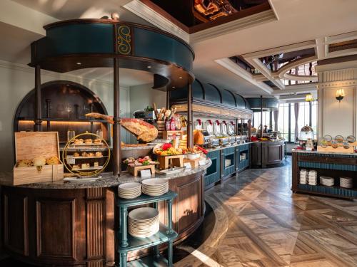 uma grande cozinha com um balcão com comida em GRAND HOTEL du LAC Hanoi em Hanói