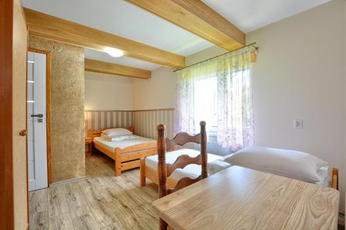 Habitación con 2 camas, mesa y ventana en olszanka, en Ustrzyki Dolne