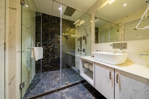 W łazience znajduje się szklana kabina prysznicowa i umywalka. w obiekcie Payel Inn w mieście Āsansol