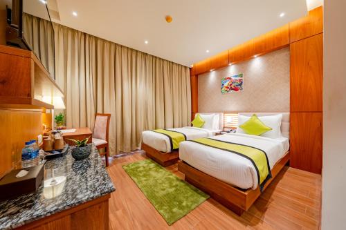 um quarto de hotel com duas camas e uma secretária em Payel Inn em Āsansol