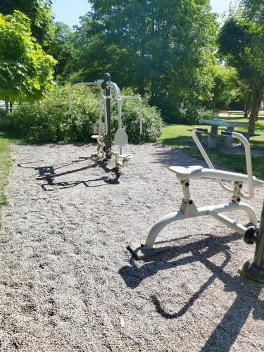 two exercise machines sitting on the ground in a park at Apartament Parkowa 2 in Morąg