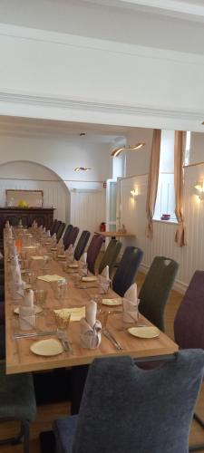 a long wooden table with chairs and plates and napkins at Gasthaus Mandelhof in Neustadt an der Weinstraße