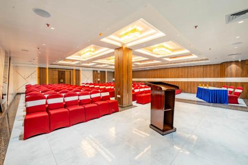 a conference room with red chairs and a podium at Payel Inn in Āsansol