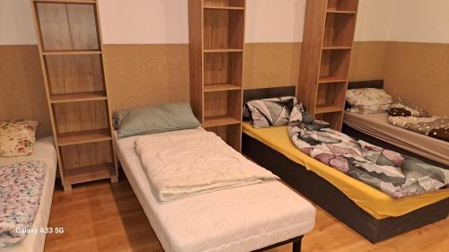 um quarto com duas camas e prateleiras com roupas em Noclegi , pokoje gościnne 