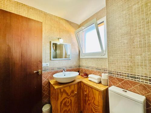 a bathroom with a sink and a window at Casa Adele terraza del mar in Corralejo
