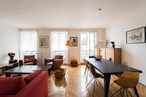 un salon avec un canapé rouge et une table dans l'établissement Legendre - Spacieux appartement à Batignolles, à Paris