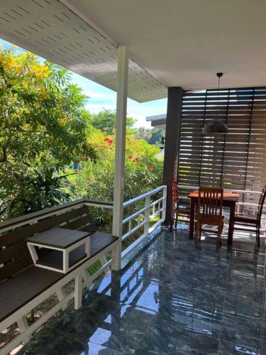 a porch with a table and chairs on a balcony at Apple Villas in Haad Chao Phao