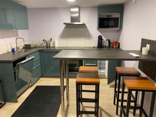 d'une cuisine avec des placards bleus et des tabourets de bar. dans l'établissement Maison Milla, à Saint-Égrève