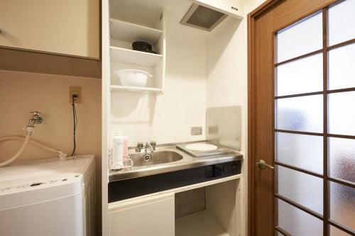 a small kitchen with a sink and a window at Garden Otsuka in Tokyo