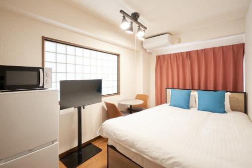 a hotel room with a bed and a tv at Garden Otsuka in Tokyo