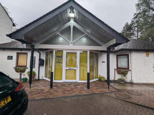 a detached house with a garage with a pitched roof at Quaysiders Lakes Resort - Quaysiders Club in Ambleside