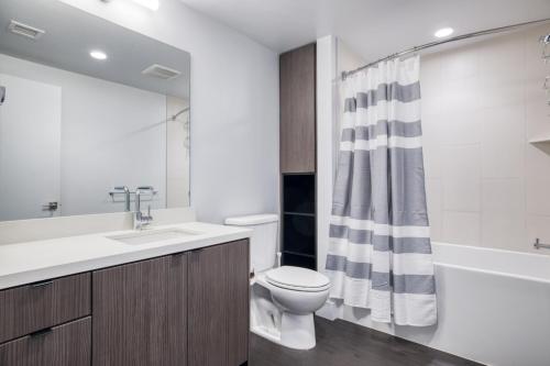 a bathroom with a toilet sink and a shower curtain at Downtown 1BR w Pool Gym nr Staples Center LAX-624 in Los Angeles