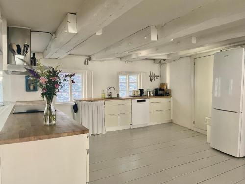 uma cozinha com electrodomésticos brancos e um vaso de flores num balcão em A Charming and Beautiful Oasis in the Heart of Copenhagen em Copenhague