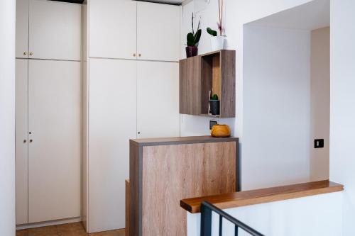 a living room with white cabinets and a staircase at Roof Garden Rooms in Assisi