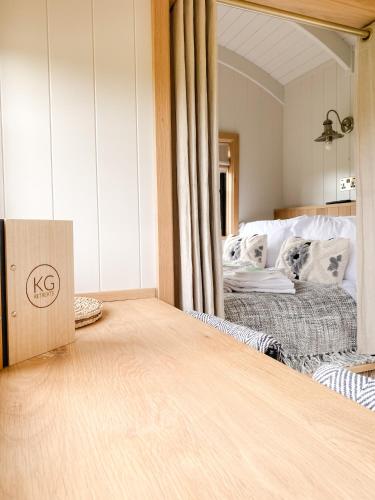 a bedroom with a bed and a large mirror at The Black Swan Shepherd Hut in Ketton