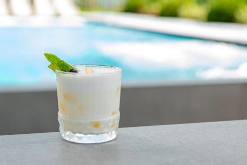 a drink sitting on a table next to a pool at REED Boutique HOTEL & BISTRO in Siófok