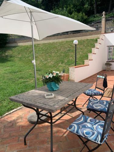 una mesa de picnic con sombrilla y 2 sillas en B&B Villa Diana en Ancona
