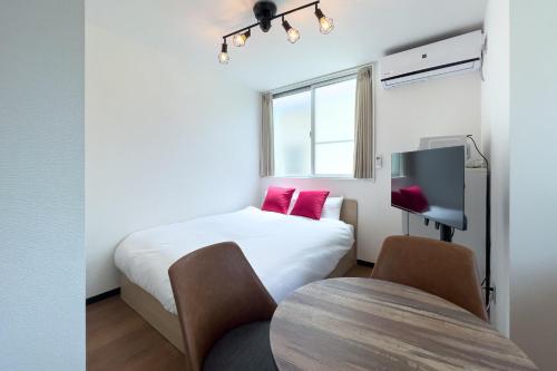 a small room with a bed and a tv at Elegant House in Tokyo