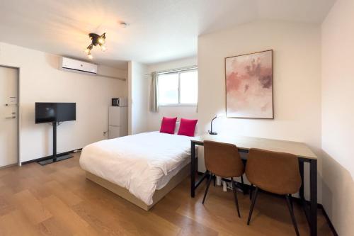 a bedroom with a bed and a table and chairs at Elegant House in Tokyo