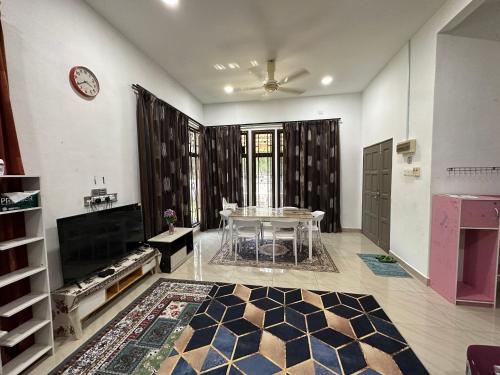 a living room with a table and a fireplace at Azzahra Homestay Pekan with 3 Bedrooms fully airconditioner in Pekan