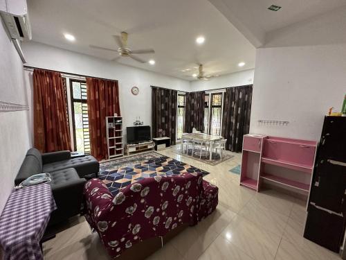 a living room with a couch and a tv at Azzahra Homestay Pekan with 3 Bedrooms fully airconditioner in Pekan