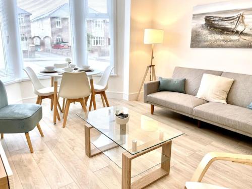 a living room with a couch and a table at Lush Porthcawl Large Spacious 2 bedroom Apt, Parking, Garden access, Prime Location in Porthcawl