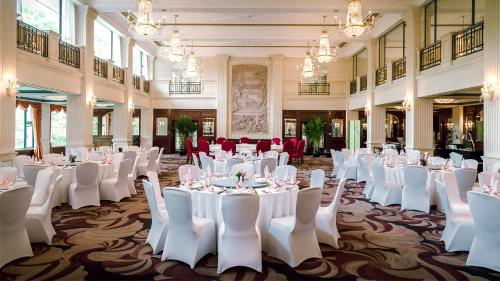 a banquet hall with white tables and white chairs at Xijiao State Guest Hotel in Shanghai