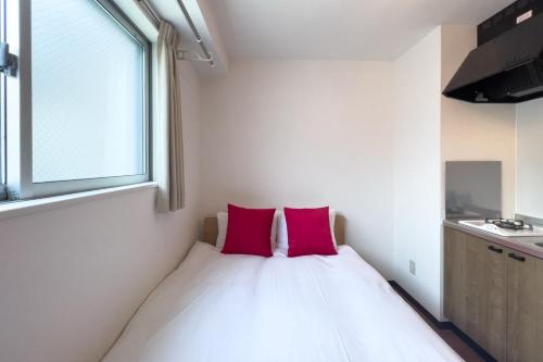 a bedroom with a bed with two pink pillows at Elegant House in Tokyo