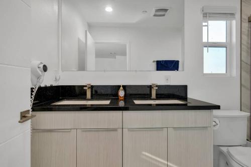 uma cozinha branca com 2 lavatórios e um WC em Wonderful 3 Bedroom Home Perfect for Getaway em Los Angeles