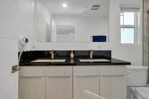 cocina blanca con 2 lavabos y aseo en Wonderful 3 Bedroom Home Perfect for Getaway, en Los Ángeles
