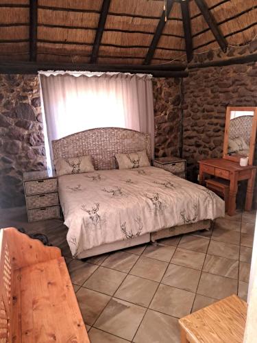 Schlafzimmer mit einem Bett, einem Fenster und einem Tisch in der Unterkunft Sunnyside cottages in Winterkamp