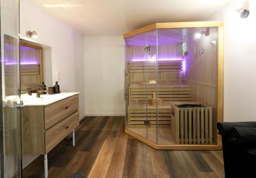 a bathroom with a shower and a sink and a glass shower at La Marionnade - Maison de village, Sauna, Balnéothérapie, Borne VE in Cerdon