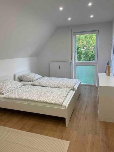 2 bedden in een witte kamer met een raam bij Messe- Augsburg- Legoland Günzburg - 6 Personen in Zusmarshausen