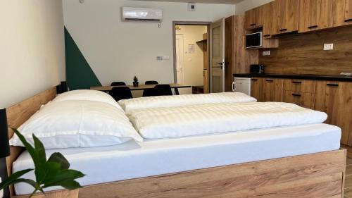 a bed with two pillows on it in a room at Rezidex Apartmanház in Szeged