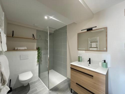 uma casa de banho com um chuveiro, um WC e um lavatório. em "L'appart du Lac" élégant, moderne et neuf - BY PRIMO C0NCIERGERIE em La Chapelle-de-Guinchay