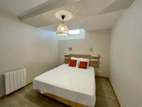 a bedroom with a white bed and a pendant light at "L'appart du Lac" élégant, moderne et neuf - BY PRIMO C0NCIERGERIE in La Chapelle-de-Guinchay